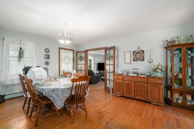 dining space featuring light hardwood / wood-style floors and baseboard heating