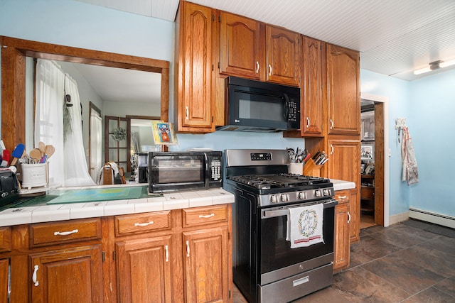 kitchen featuring dark tile patterned flooring, tile counters, and stainless steel gas range oven