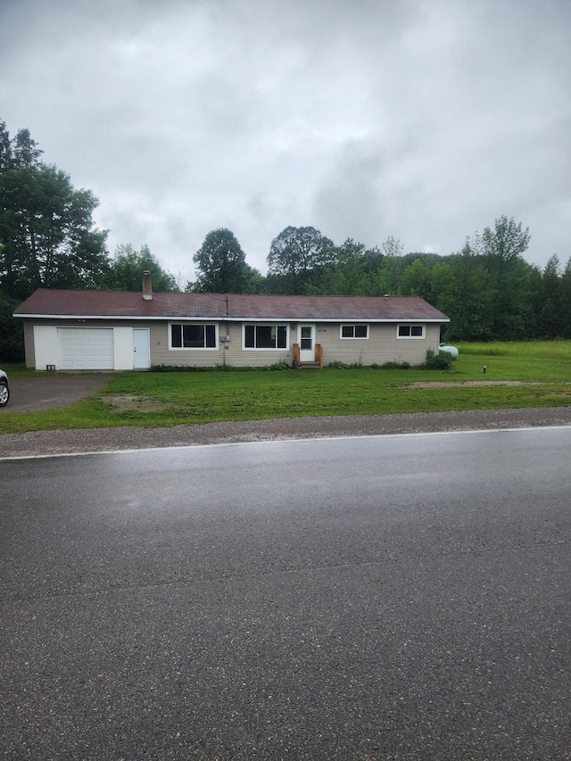 ranch-style home with a garage and a front yard