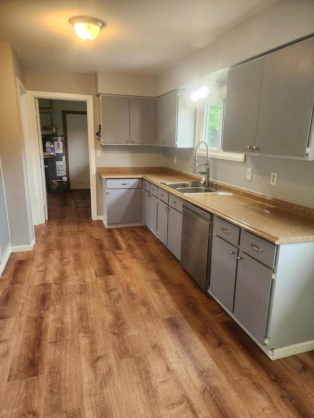 kitchen featuring dishwasher, gas water heater, sink, gray cabinets, and light wood-type flooring