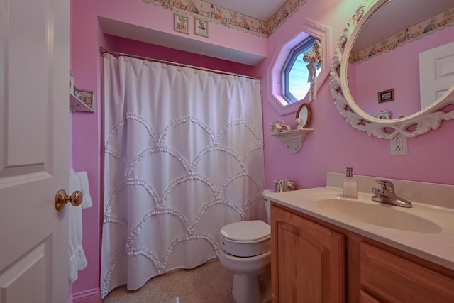 bathroom featuring vanity, toilet, and walk in shower