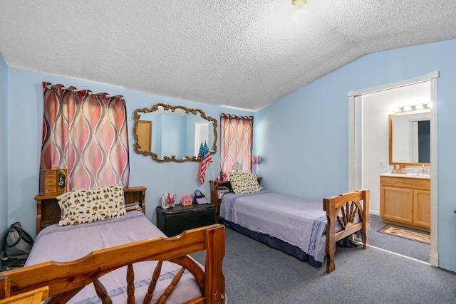 carpeted bedroom with ensuite bath, vaulted ceiling, and a textured ceiling