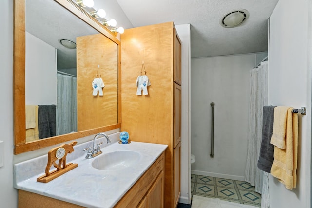 bathroom featuring vanity, toilet, and a textured ceiling