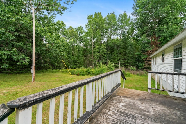 wooden deck featuring a lawn