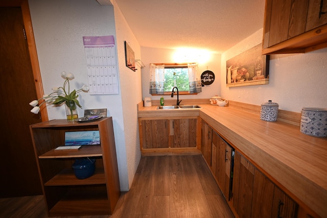 hall featuring sink, a textured ceiling, and hardwood / wood-style flooring