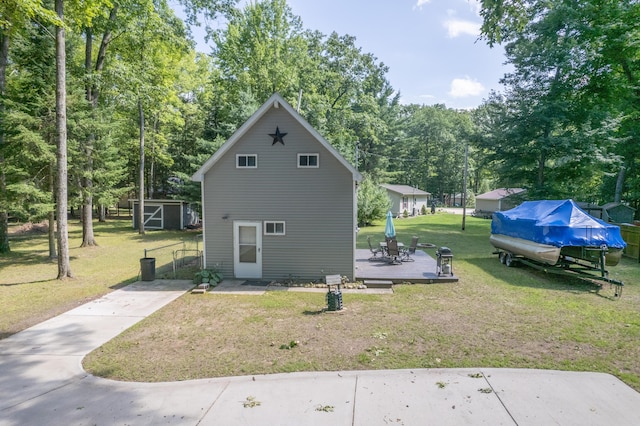 view of side of home with a deck, a lawn, and a storage shed