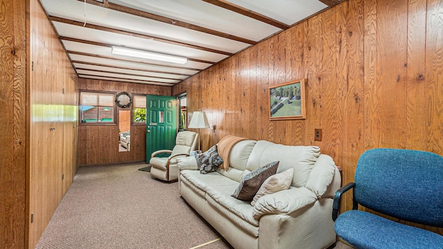 living room featuring beam ceiling, light colored carpet, and wood walls