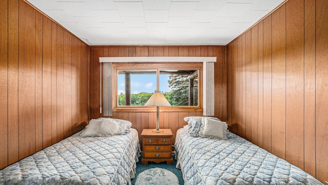 carpeted bedroom with wooden walls