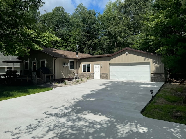 single story home featuring a wall mounted AC and a garage