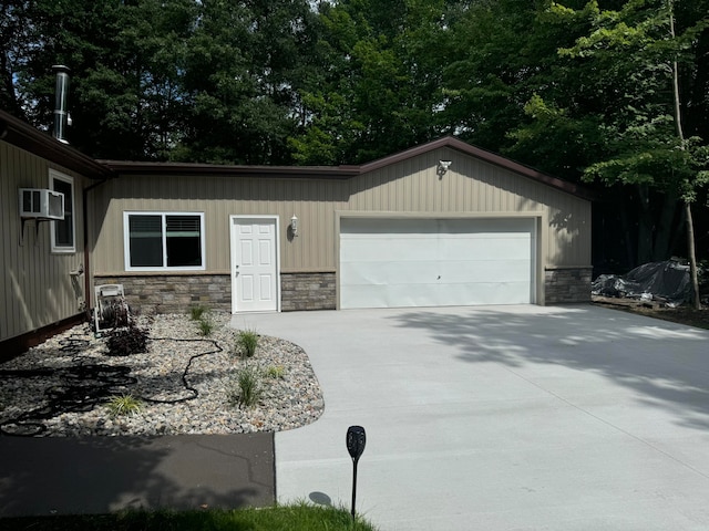 view of front of property featuring a wall mounted air conditioner and a garage