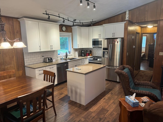 kitchen with sink, a center island, white cabinetry, stainless steel appliances, and dark wood-type flooring