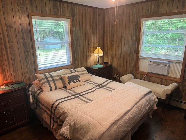 bedroom with wood walls, multiple windows, and dark hardwood / wood-style flooring