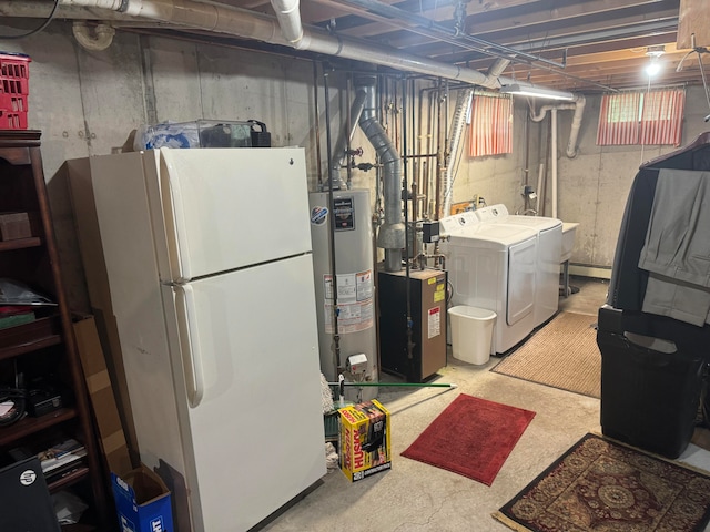 basement featuring washer and dryer, water heater, and white fridge