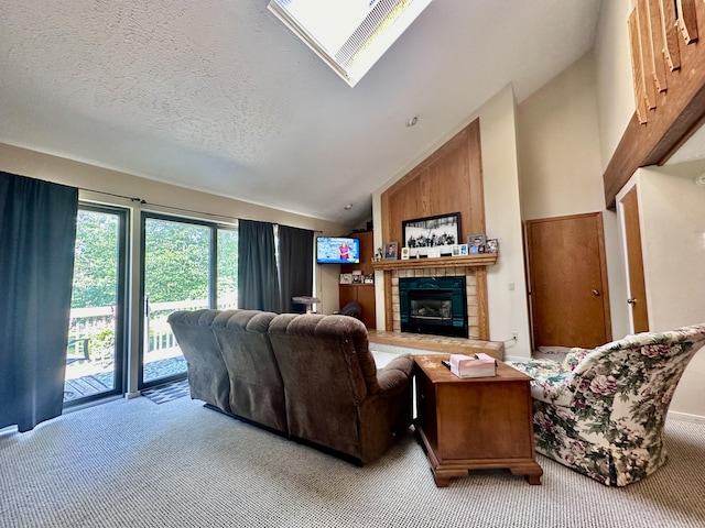 carpeted living room with a tiled fireplace, a textured ceiling, and lofted ceiling with skylight