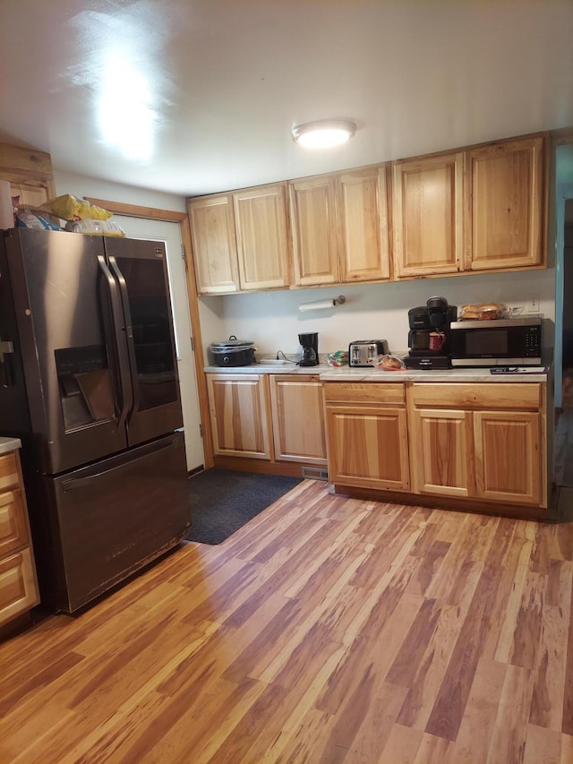 kitchen featuring appliances with stainless steel finishes and light hardwood / wood-style flooring