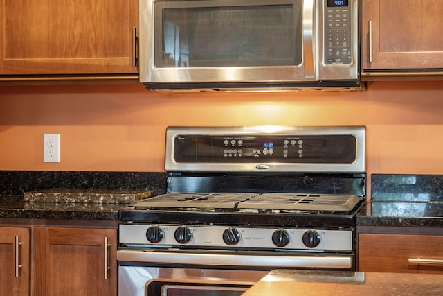 kitchen with dark stone counters and stainless steel appliances