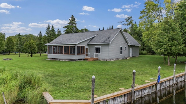 rear view of house featuring a yard and a sunroom