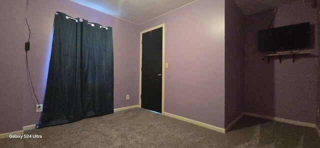 carpeted empty room with lofted ceiling