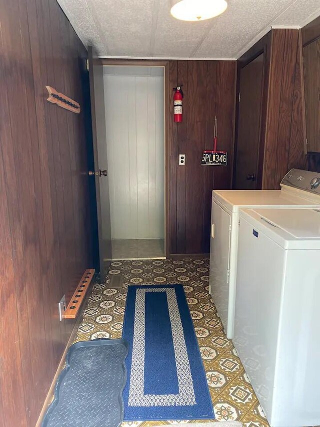 washroom featuring washer and dryer and wooden walls