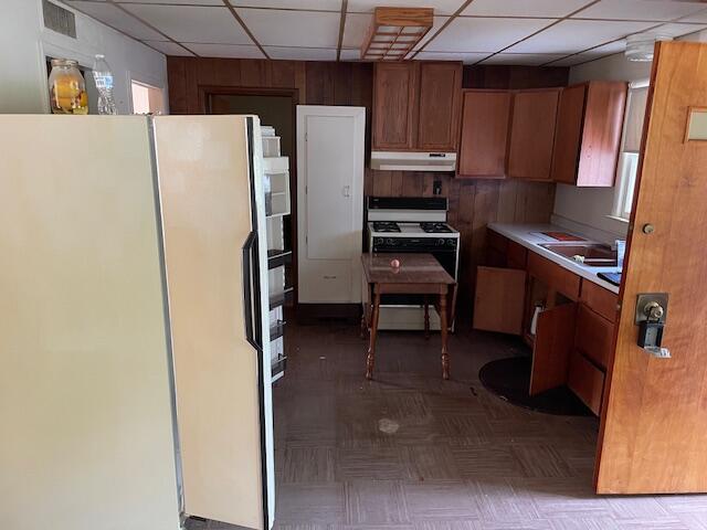 kitchen featuring a drop ceiling, parquet flooring, and white appliances