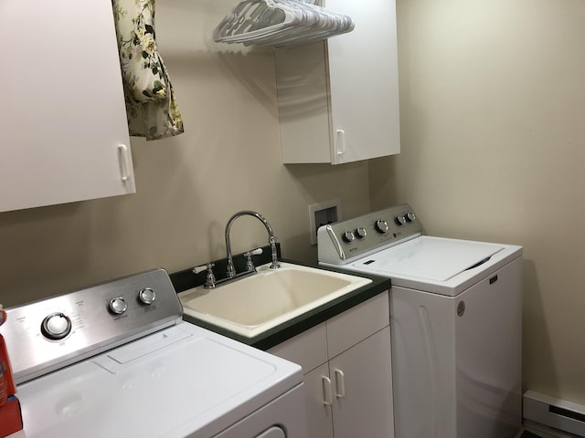 clothes washing area with cabinets, sink, and washer and dryer