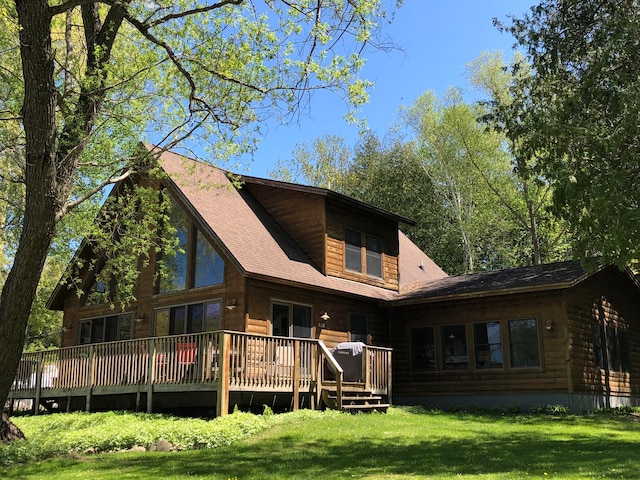 rear view of property with a yard and a deck