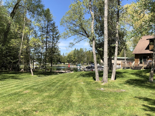 view of yard with a deck with water view