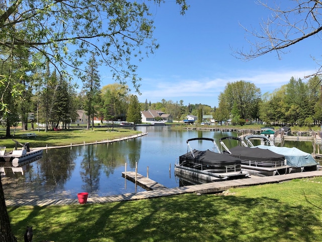 view of dock with a yard and a water view