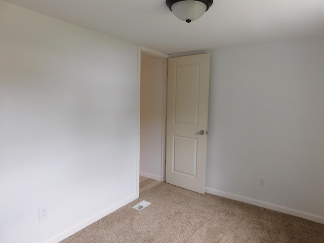 unfurnished room featuring light colored carpet