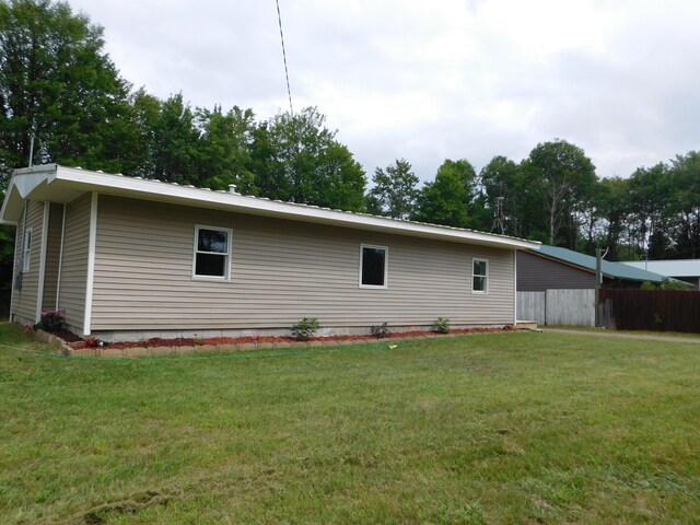 rear view of property featuring a lawn