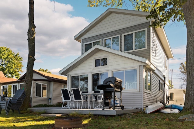 back of property with a lawn and a deck