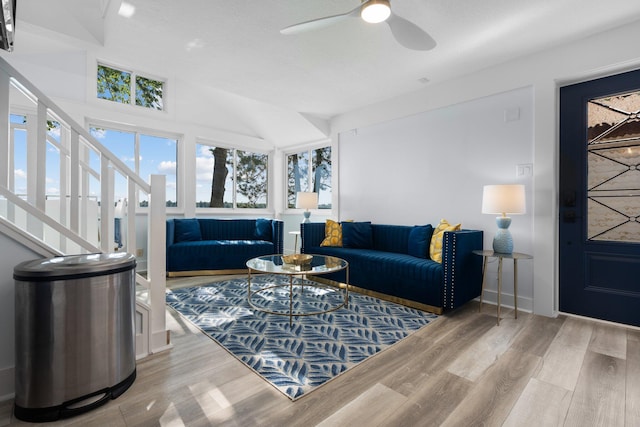 living room featuring a textured ceiling, light hardwood / wood-style flooring, ceiling fan, and lofted ceiling