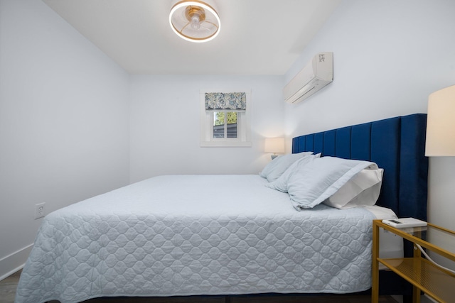 bedroom with a wall mounted air conditioner and hardwood / wood-style flooring