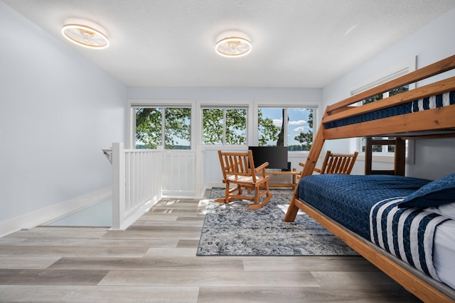 bedroom featuring light wood-type flooring and a textured ceiling