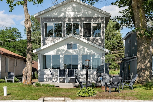 back of house with a lawn and a sunroom