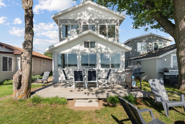 rear view of property with a deck and a sunroom