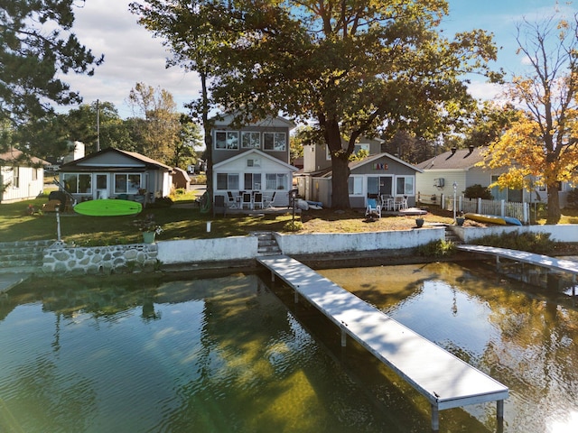 dock area with a lawn and a water view