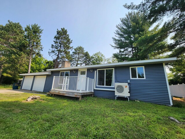 view of front of house featuring a deck, a garage, and a front lawn