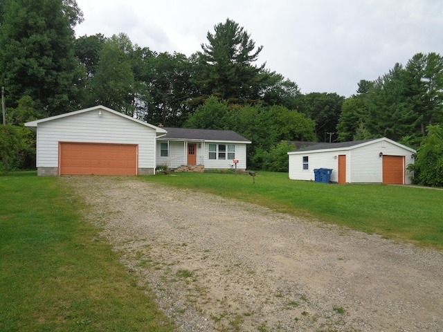 view of front of home with a garage, a front lawn, and an outbuilding