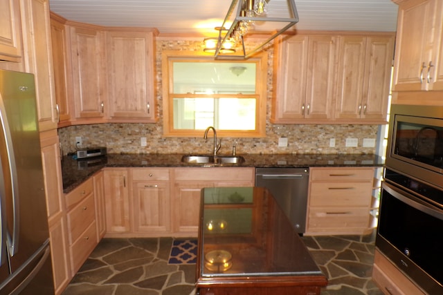 kitchen with light brown cabinetry, sink, appliances with stainless steel finishes, and dark stone counters