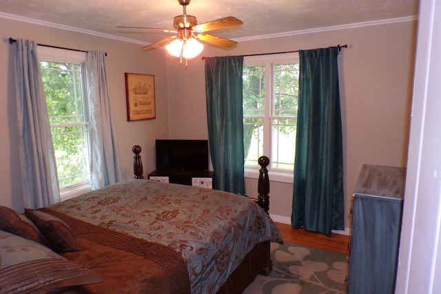 bedroom with multiple windows, ceiling fan, and ornamental molding