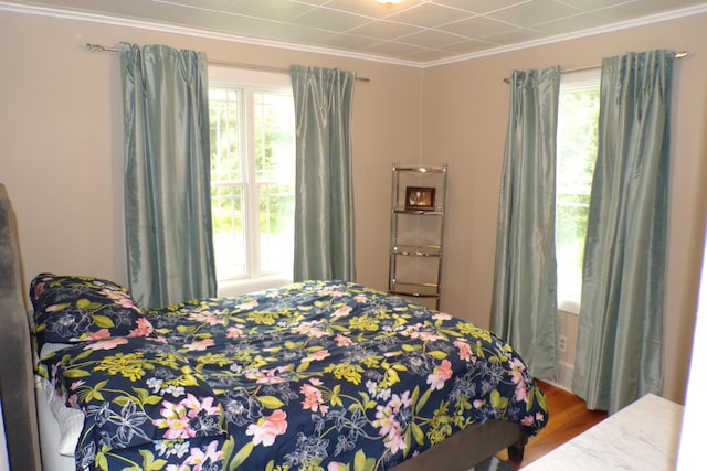 bedroom with hardwood / wood-style floors and ornamental molding