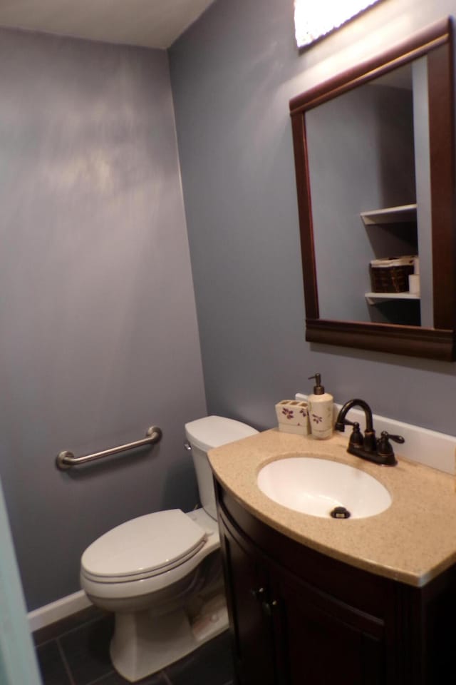 bathroom with tile patterned flooring, vanity, and toilet