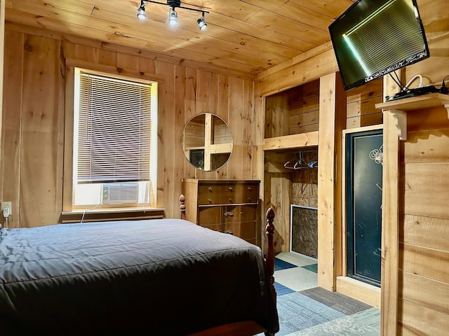 bedroom with cooling unit, wood walls, wooden ceiling, and rail lighting