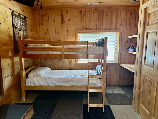 bedroom featuring wood walls and tile patterned flooring