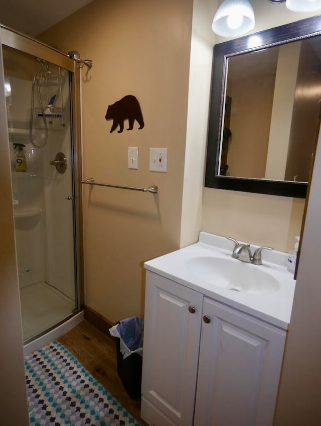 bathroom with walk in shower, wood-type flooring, and vanity