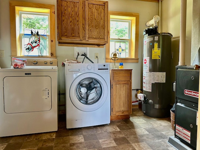 washroom featuring washing machine and clothes dryer, water heater, cabinets, and dark tile patterned floors