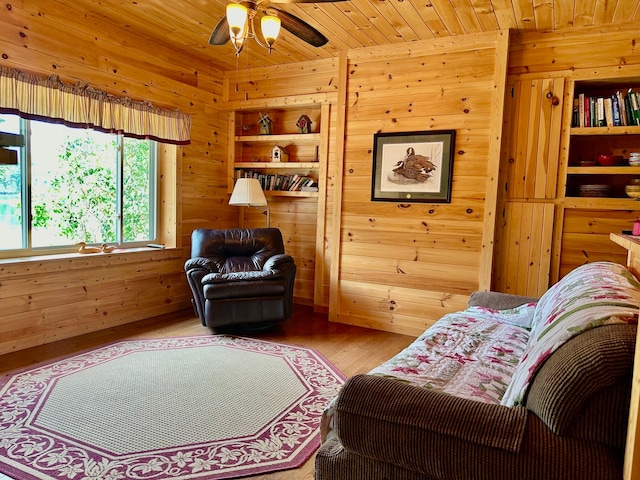 living room featuring wood ceiling, wooden walls, ceiling fan, and wood-type flooring