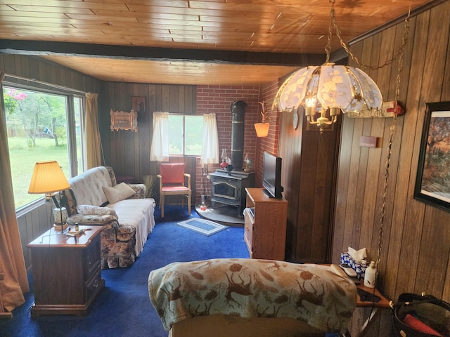 carpeted bedroom with wood walls, a wood stove, beamed ceiling, and wood ceiling