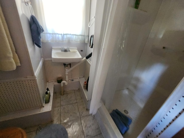 bathroom with a shower, sink, and tile patterned flooring